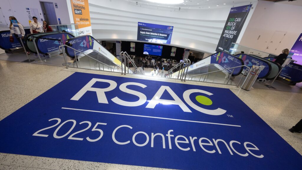 Large blue floor decal reading RSAC 2025 Conference at the venue entrance near escalators
